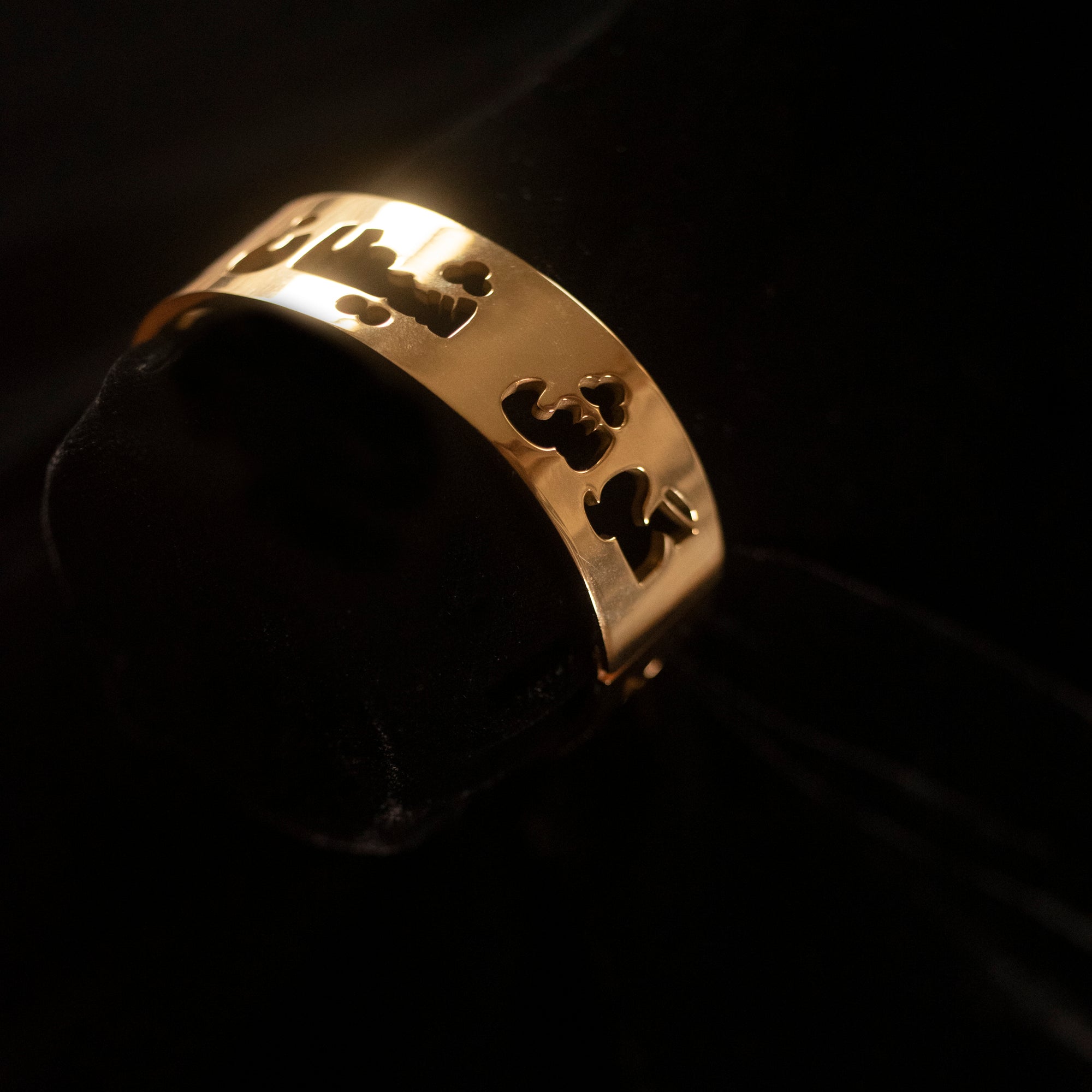 A gold bangle that says may the devils ears be deaf in Dari.