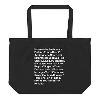 Black tote bag with white text listing various city names on a white background