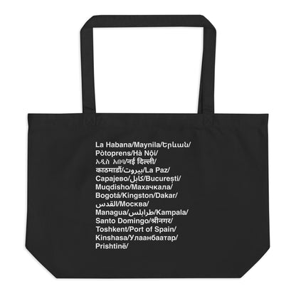 Black tote bag with white text listing various city names.