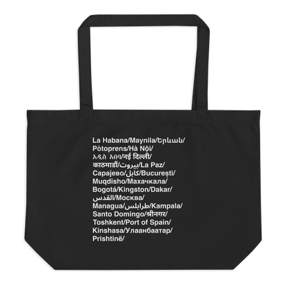 Black tote bag with white text listing various city names.