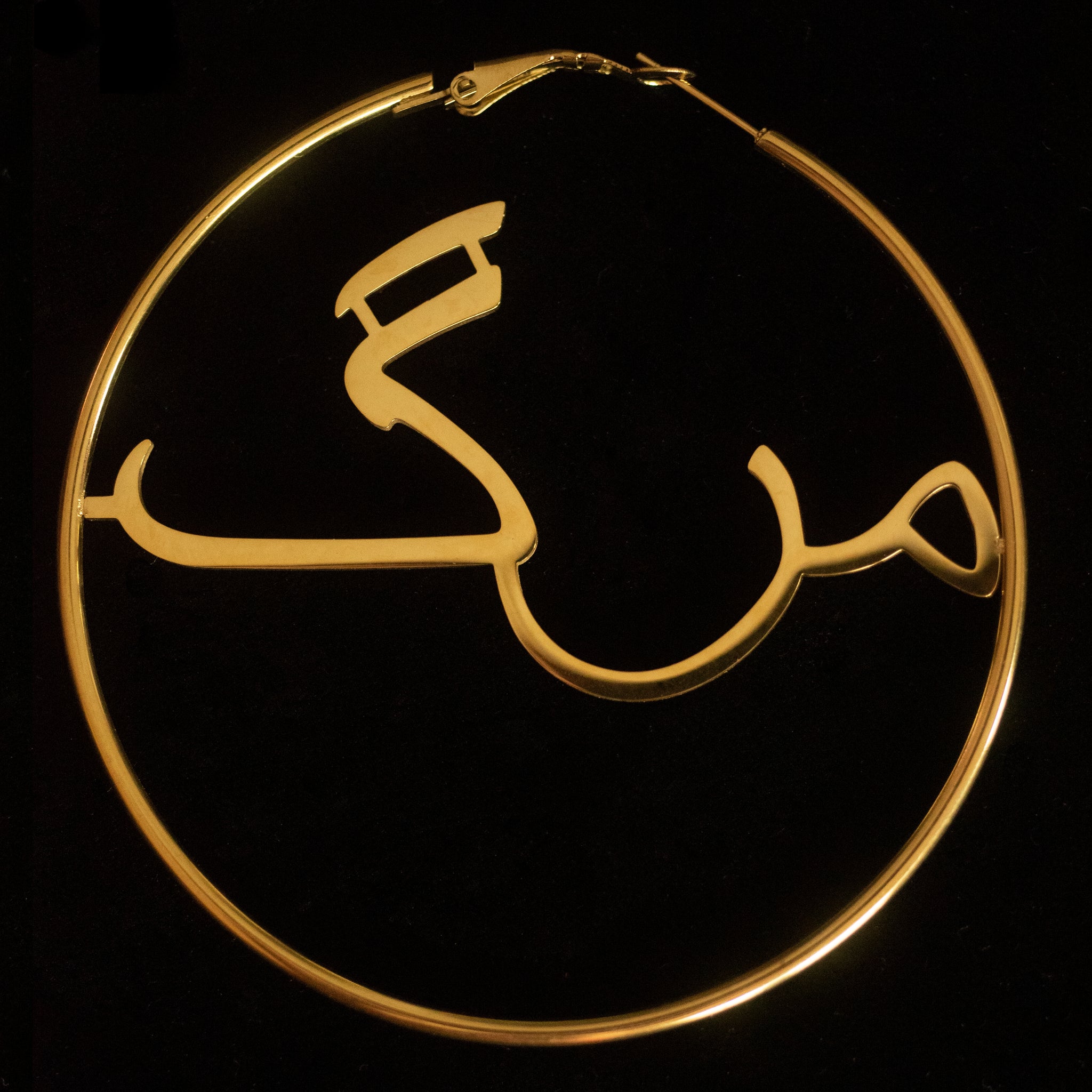 Against a black background sits a gold hoop that says the word 'marg' in the middle.