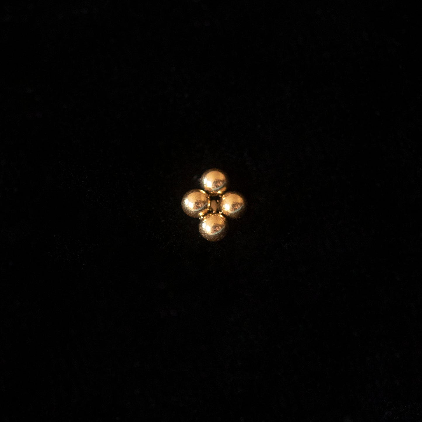 A gold stud against a black backdrop.