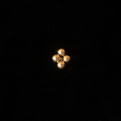 A gold stud against a black backdrop.
