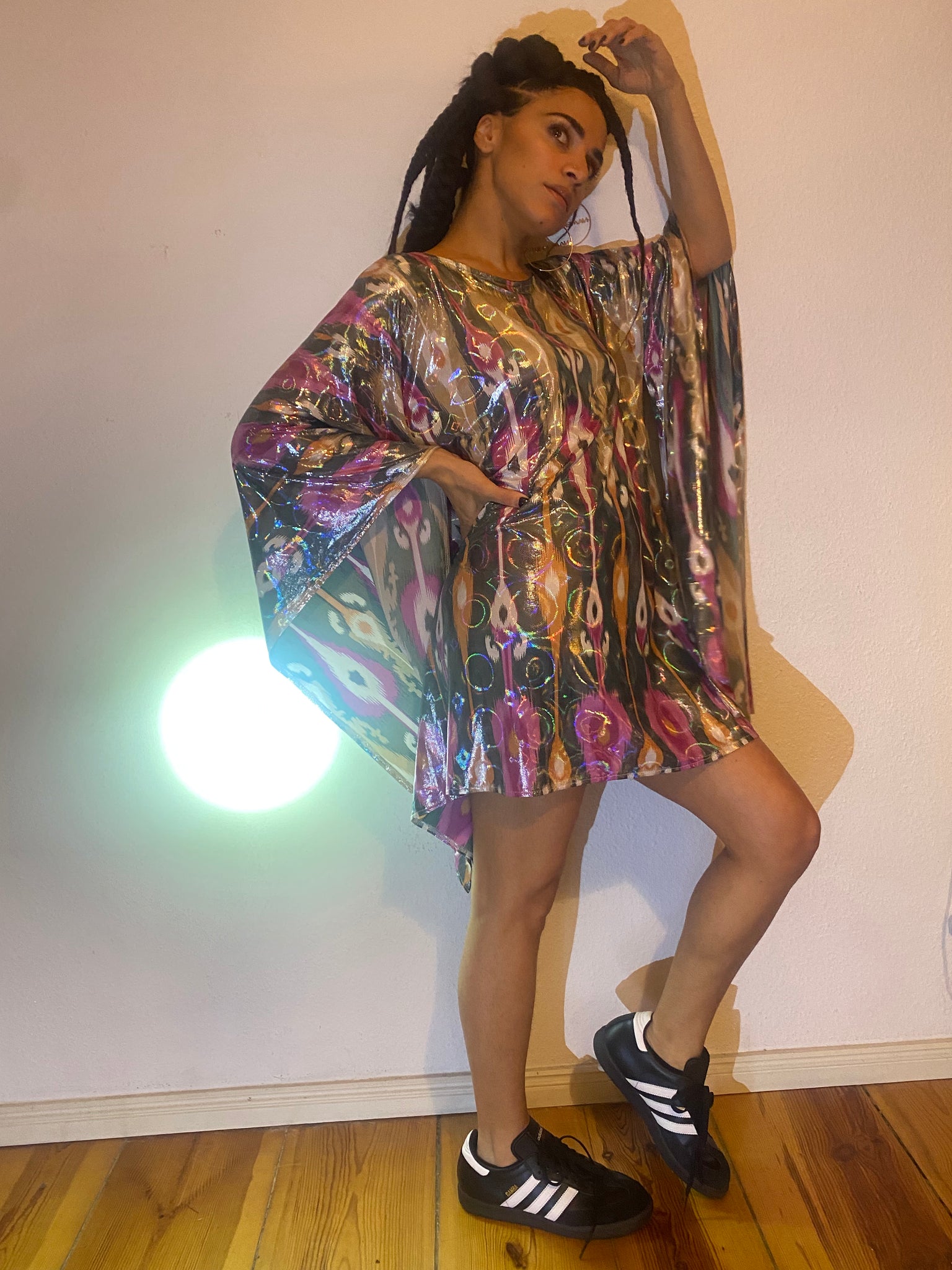 A woman in a colourful ikat mini dress poses with the light.