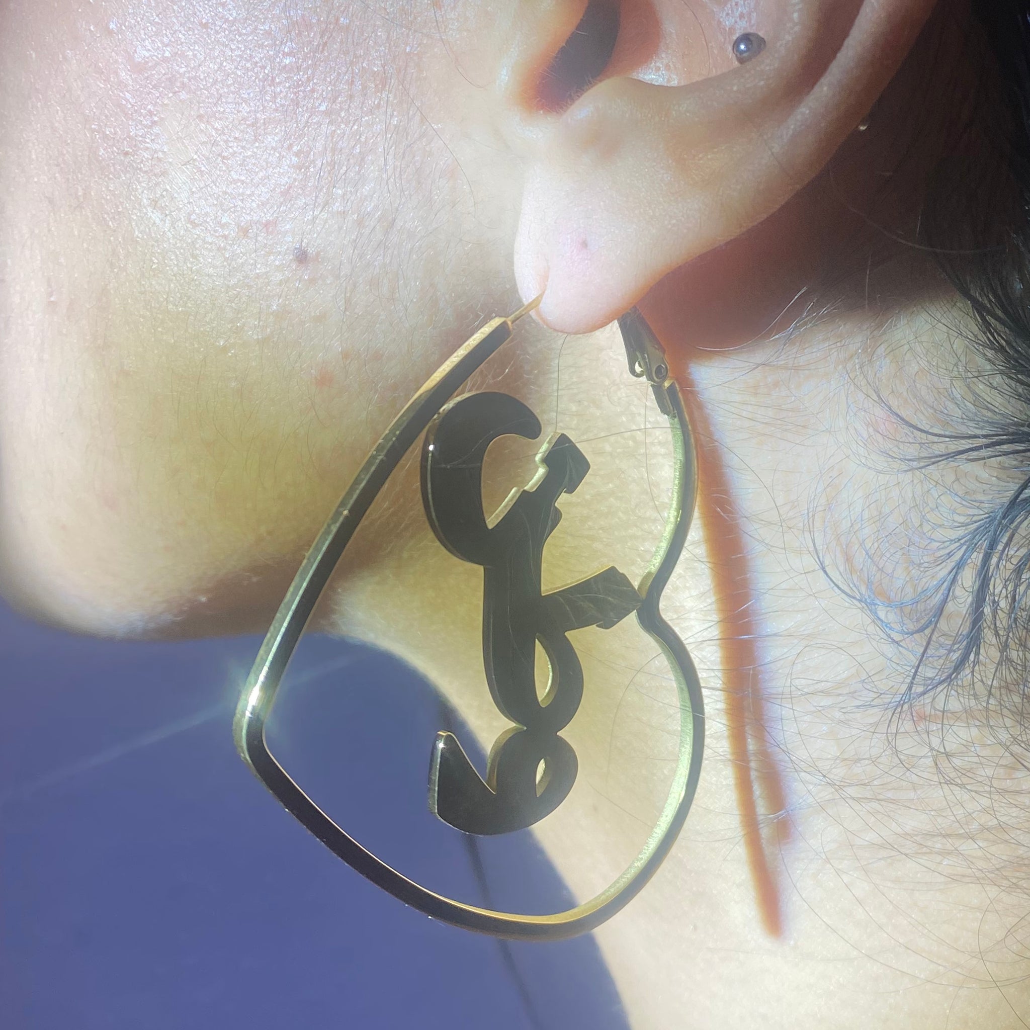 A close up of ear wearing 'watan' heart hoops.