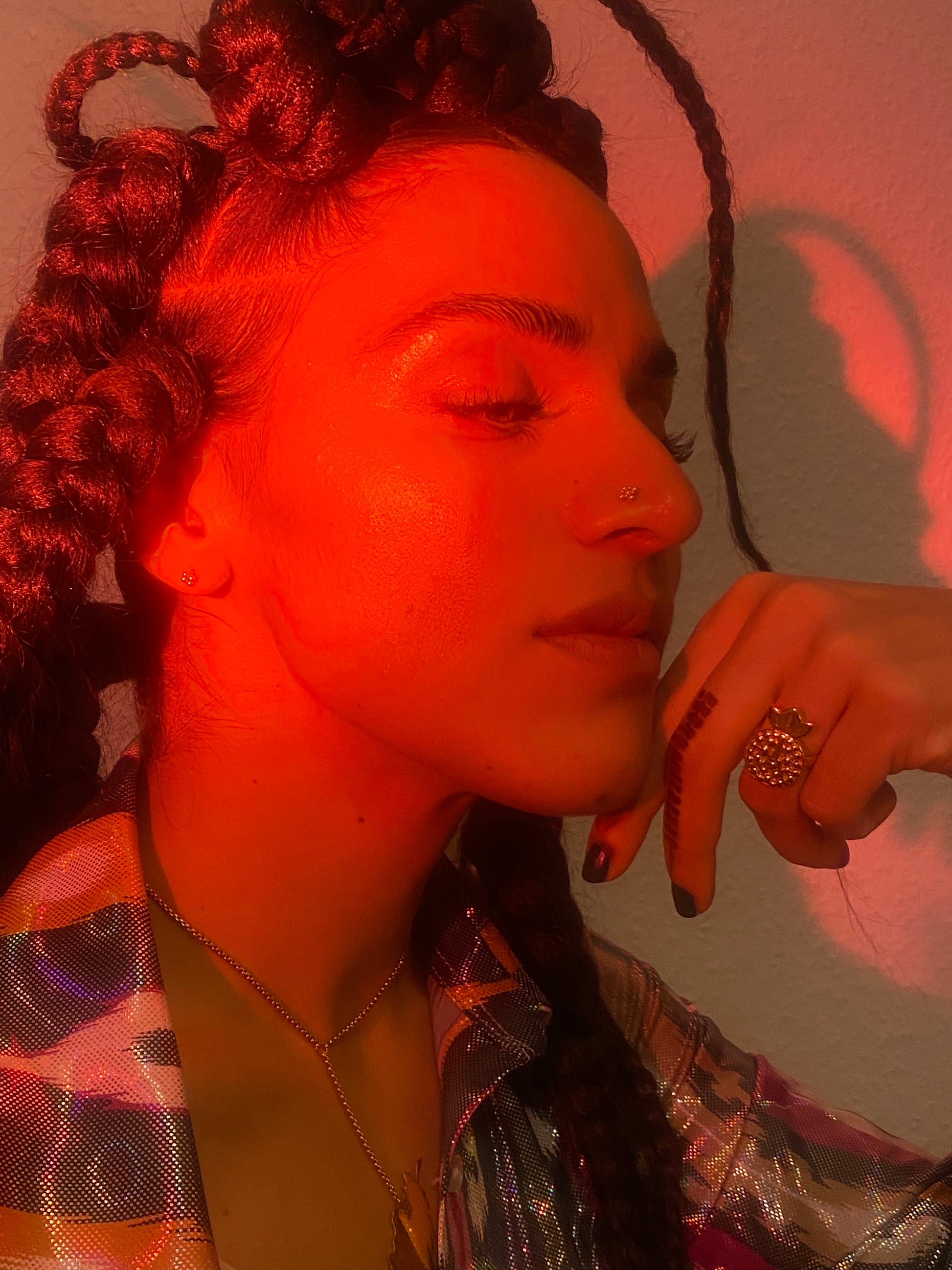 Woman under red lighting with anaar ring.