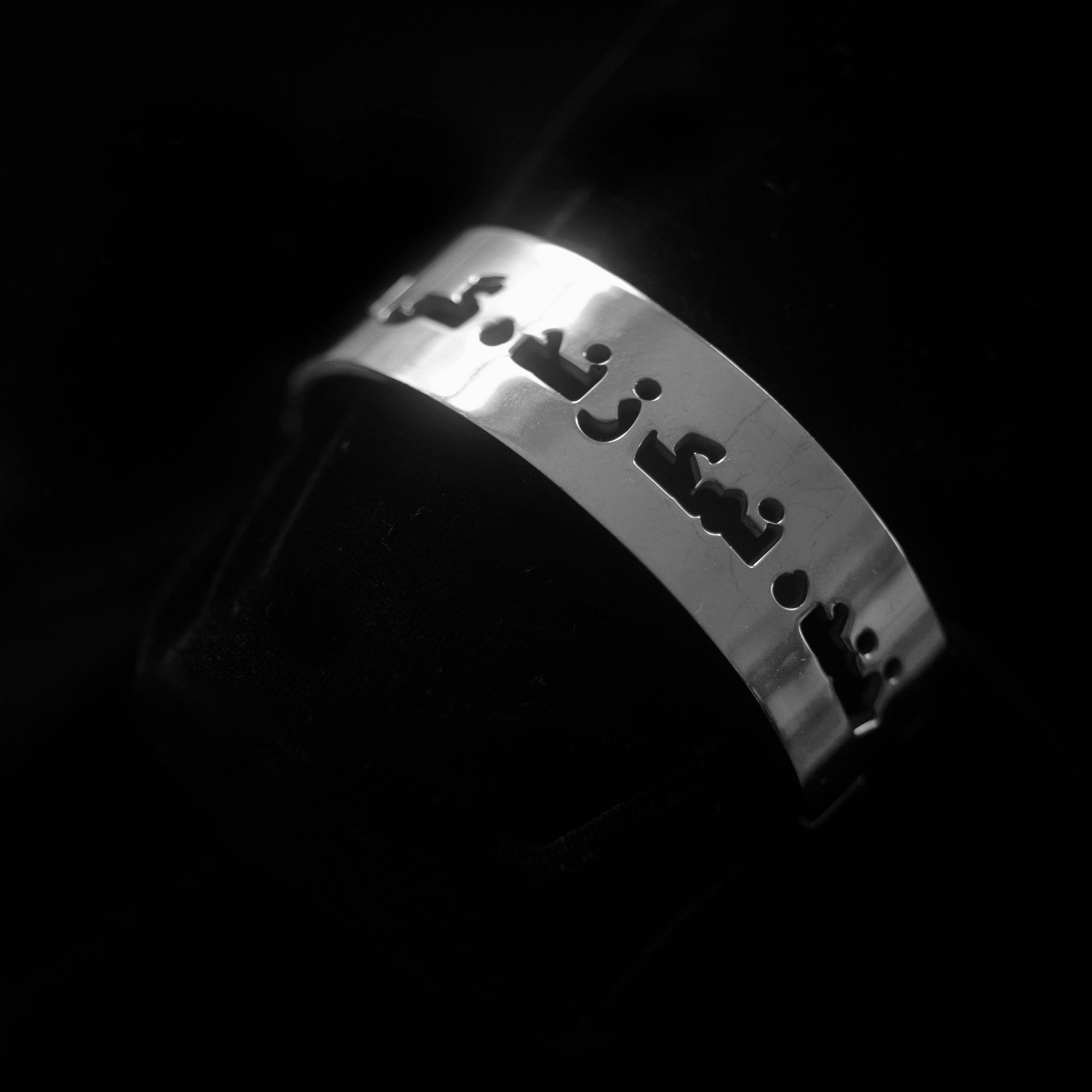 A silver bangle that says laughter is the salt of life in Dari.