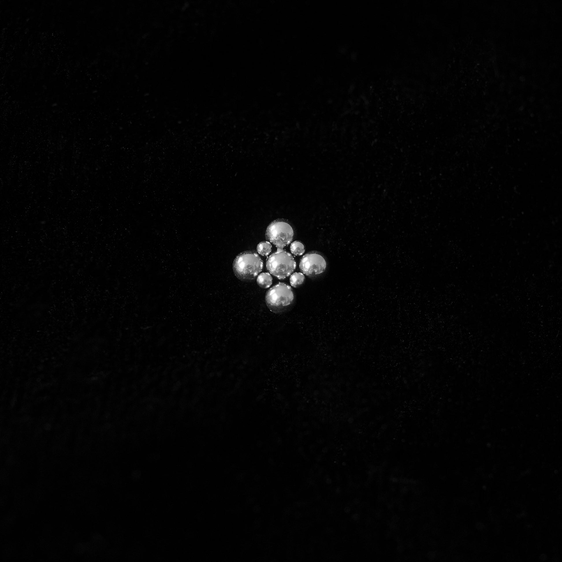 Sheenkhaal tribal tattoo inspired nose stud in silver against a black backdrop.